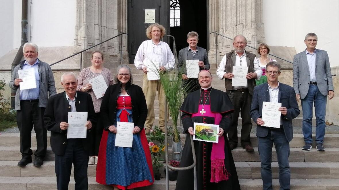 Nach der Urkundenübergabe (v.l.): Ottmar Vellinger (Straßberg), Christoph Kähny (Willishausen), Gertrud Hitzler (Aindling), Elfriede Ebner (Kaufbeuren), Helmut Heiler (Kaufbeuren), Anton Eichner (Pfründestiftungsverbund), Bischof Bertram, Reinhold Gradl (Kaufbeuren), Andrea Kaufmann-Fichtner (Umweltbeauftragte Bistum Augsburg), Dieter Kling (Unterbechingen), Siegfried Fuchs (Umweltberater). (Foto: Fachbereich Kirche und Umwelt)
