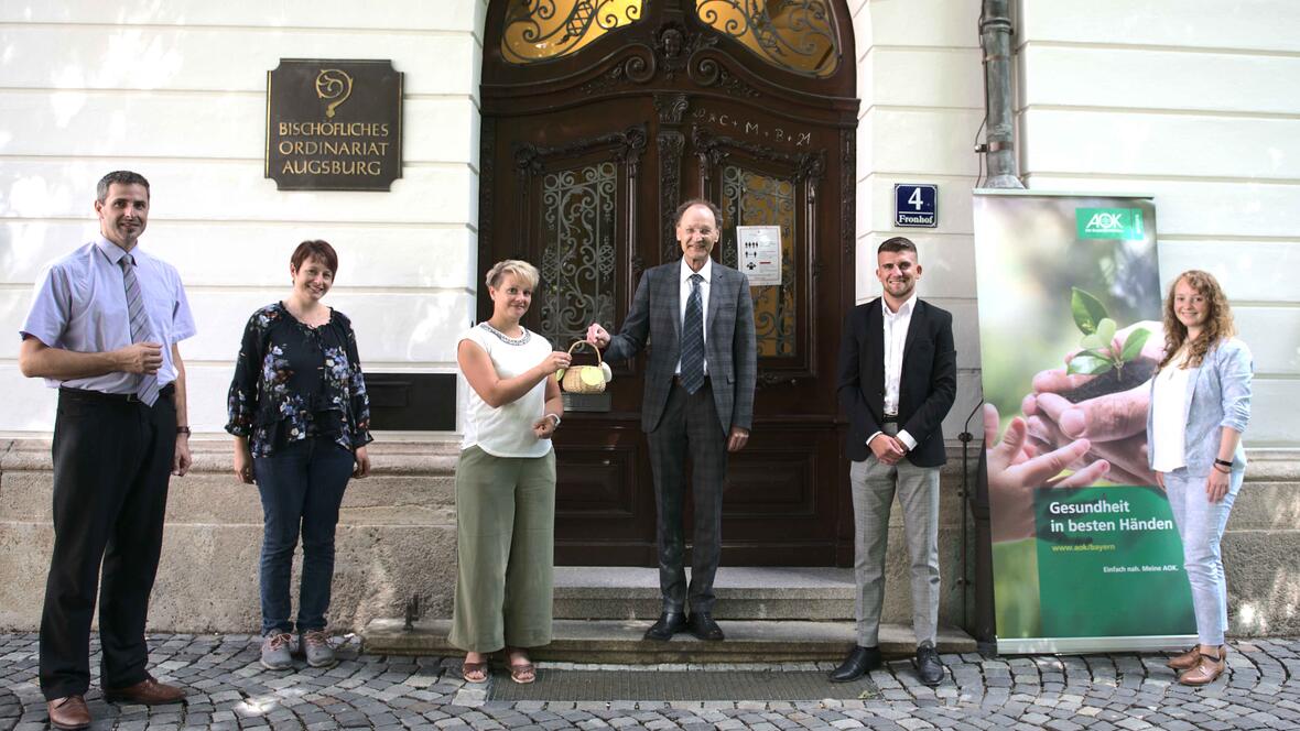 Generalvikar Dr. Wolfgang Hacker hat per Losziehung die Gewinner des Gesundheitstags ermittelt. Neben dem Projektteam waren auch Mitarbeiter der AOK Bayern dabei (Maria Steber / pba).