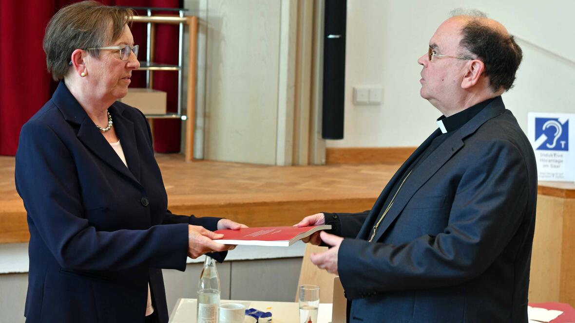 Die Leiterin der Projektgruppe Reitenbuch Elisabeth Mette überreicht Bischof Dr. Bertram Meier den Abschlussbericht. (Foto Nicolas Schnall / pba)