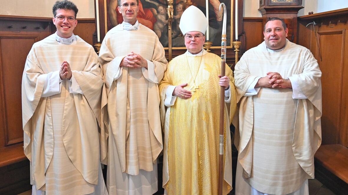 Strahlende Neupriester zusammen mit ihrem Weihespender. 