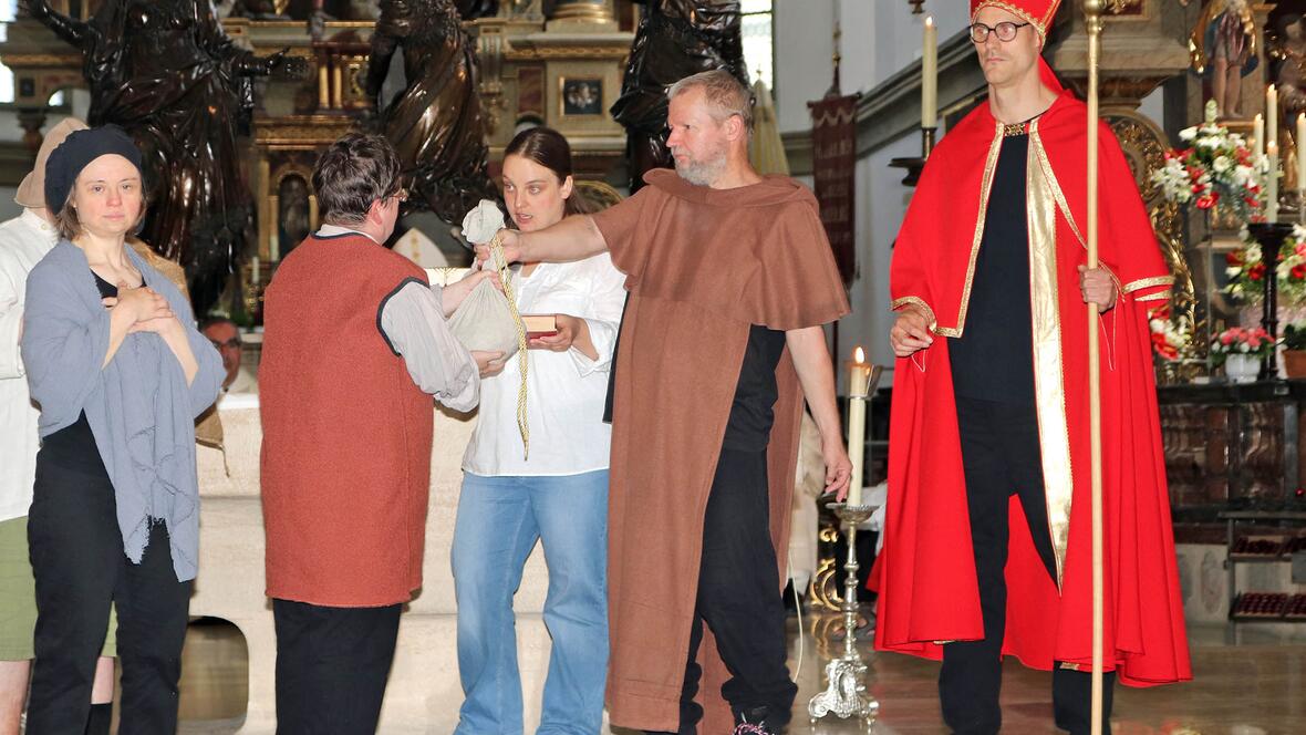 Die Theatergruppe der CAB-Caritas aus Mering führte vor dem Altar in der Ulrichsbasilika ein kleines Theaterstück auf und erzählte davon, dass der Augsburger Bistumspatron trotz aller Zerstörung, des Hungers und Leides den Menschen Mut machte, indem er ihnen in ihrer Not half. (Foto: Caritas Augsburg / Bernhard Gattner)
